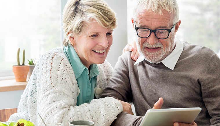 Older couple reading about health savings account on ipad