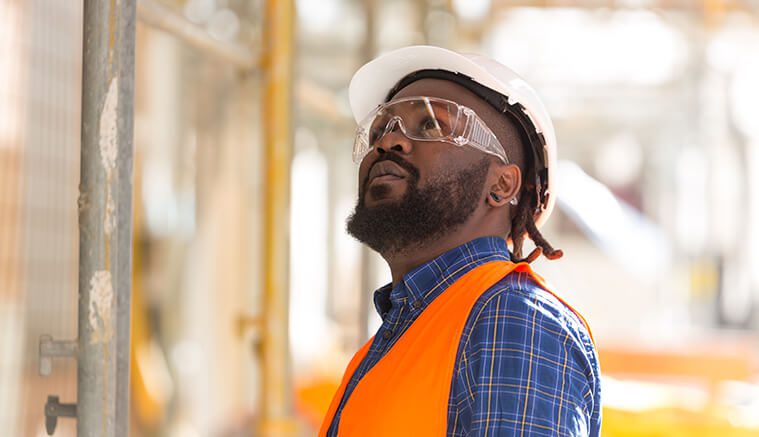 Black male construction worker evaluating water pipes