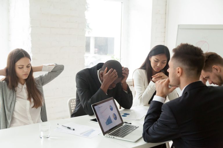Diverse workers in meeting frustrated over business startup mistakes