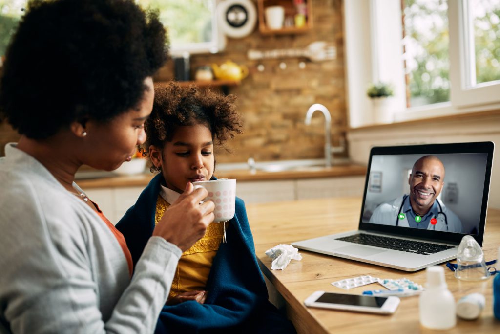 Black mother with sick child using Well-Being plan to have TelaDoc call with Black doctor