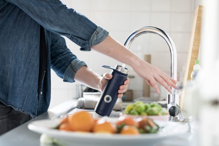 refilling water bottle in kitchen healthy food