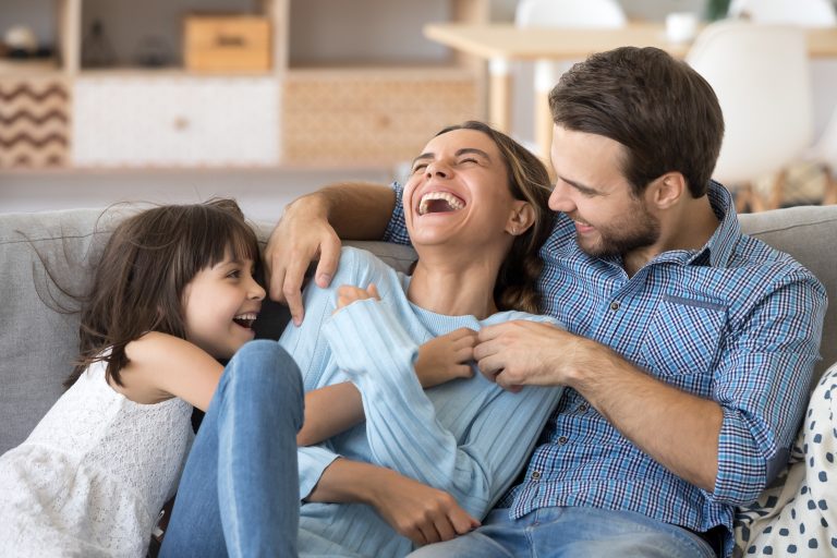 laughing family on sofa